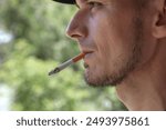 The elderly man smokes a cigarette