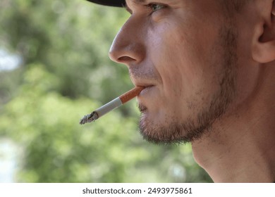 The elderly man smokes a cigarette - Powered by Shutterstock