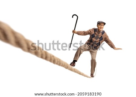 Elderly man standing on a rope and keeping balance isolated on white background