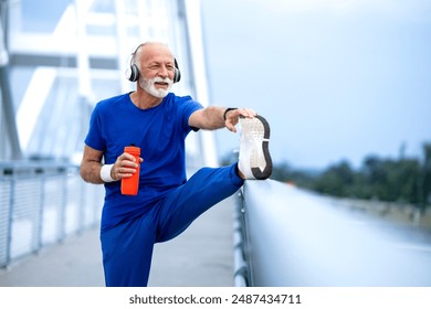 Elderly man stretching his legs and preparing for running. - Powered by Shutterstock