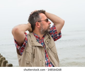 Elderly man suffering from headache on the sea background