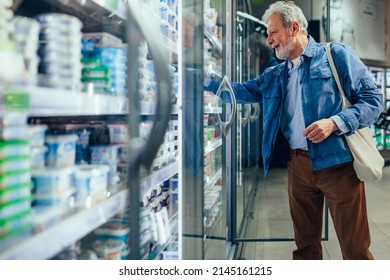 Elderly Man Supermarket Grocery Shopper Looking At Refrigerated Searching For Milk Product