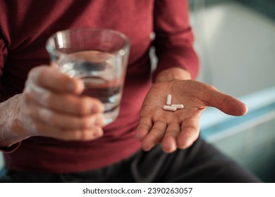 Elderly man taking medication in bathroom - Powered by Shutterstock