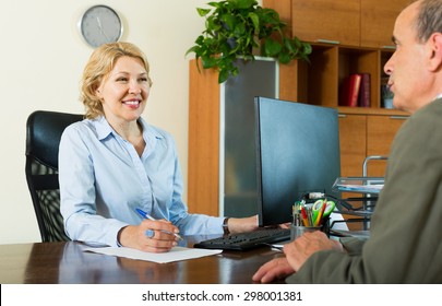 Elderly Man Talking With Bank Manager About Opening Saving Account