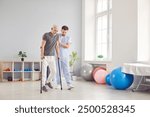 An elderly man undergoes rehabilitation after surgery in a clinic. A male physical therapist helps a patient after a leg injury in a rehabilitation center.