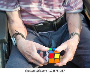 Elderly man uses a cube puzzle as therapy for his diminished mental capacity due to brain damage and stroke caused by a serious fall and injury at his home.