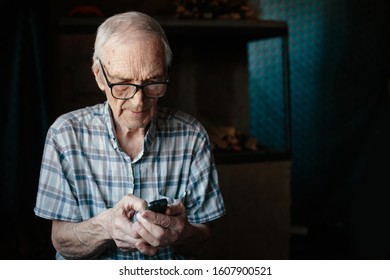 Elderly man using small cell phone  at home