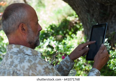 Elderly man using tablet / elderly man reading ebook