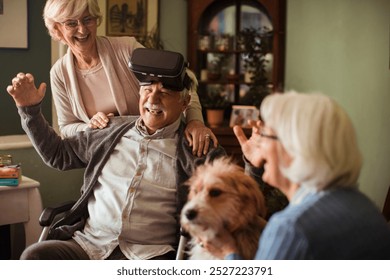 Elderly man using virtual reality headset in wheelchair assisted by elderly woman - Powered by Shutterstock