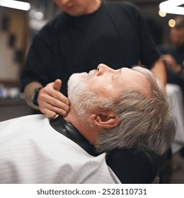 Elderly man visiting barber shop. Barber checking client neck area, ensuring smooth lines and clean shave. Detailed grooming. Concept of male beauty, barbershop, hairstyle, salon, hairdresser - Powered by Shutterstock