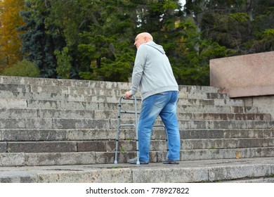 Elderly Man With Walking Frame Going Up The Stairs Outdoors