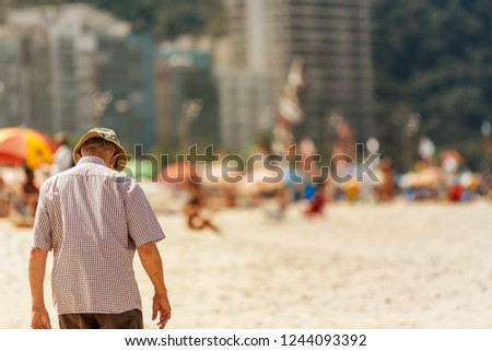 Elderly man walking head down on Copacabana beach in Rio de Janeiro, Brazil