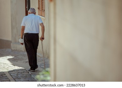 Elderly man walking on cobblestone in the old town of Erice, Sicily - Powered by Shutterstock