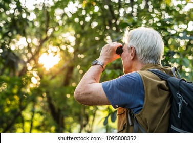 Elderly man watching birds with binoculars - Powered by Shutterstock