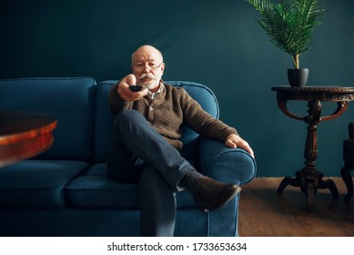 Elderly Man Watching TV On Couch In Home Office