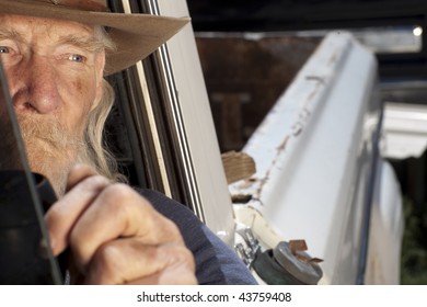 An Elderly Man With A White Beard Driving A Pickup Truck And Staring Out The Window