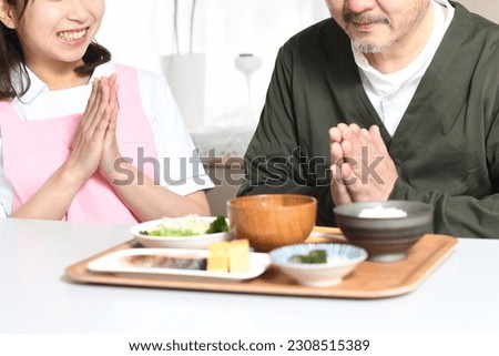 An elderly man who eats and a female caregiver in an apron
 Foto stock © 