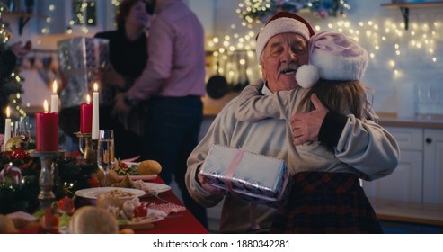 Elderly man with wife welcoming loving children and grandchildren with gifts while gathering for Christmas dinner celebration - Powered by Shutterstock