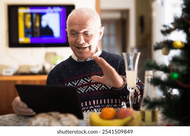 Elderly man wishes Merry Christmas by laptop - Powered by Shutterstock