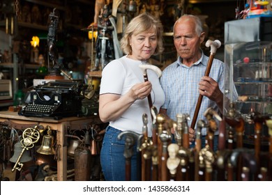 Elderly Man And Woman Examine Rare Walking Stick On Flea Market