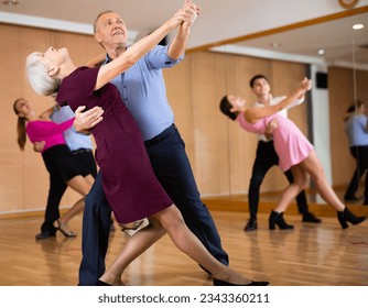 elderly man and woman having fun learning to dance waltz - Powered by Shutterstock