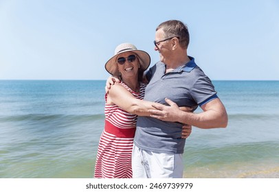 An elderly man and woman hugging on the seashore on a sunny day. Love and tenderness. A happy family.  - Powered by Shutterstock