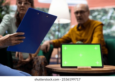 Elderly man and woman talking to nurse at their home with a green screen on tablet, having a fun chat together and asking for guidance. Senior couple feeling good, relaxing at checkup visit. - Powered by Shutterstock