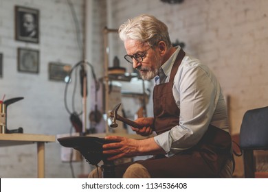 An elderly man at work in the workshop - Powered by Shutterstock