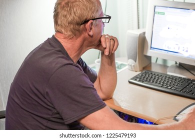 An Elderly Man Working At The Computer At Home