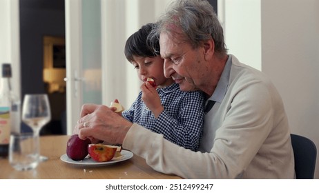 Elderly man and young boy bonding over apple slices, grandparent guiding child, intergenerational family moment, hands-on learning, apple peeling, shared snack time, home environment - Powered by Shutterstock