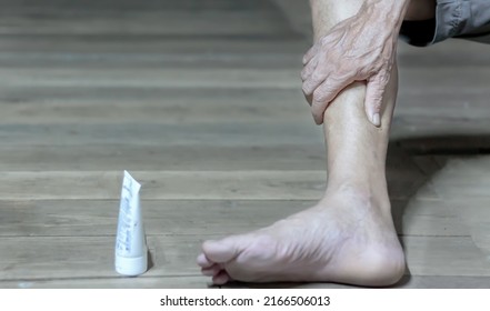 Elderly man's leg injury or pain on a wooden floor