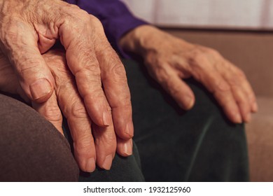 Elderly marriage couple. Close up aged hands. Unrecognizable caucasian woman's and man's hands. Old marriage couple on sofa. 