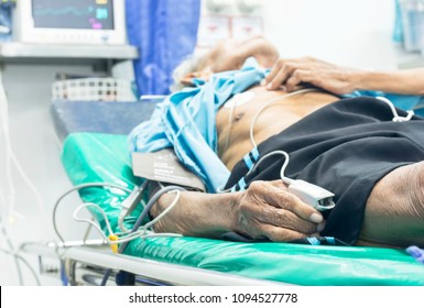 Elderly Men Are Couch Electrocardiogram Monitor To Assess The Condition Of The Heart Due To Chest Pain At The Emergency Room Of The Hospital.