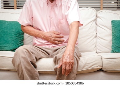 Elderly men have abdominal pain sitting on the sofa in the house. Concept
Problems of the digestive tract in older people, health care
