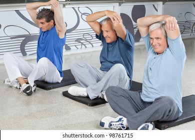 Elderly Men Stretching In Fitness Center On Gym Mats