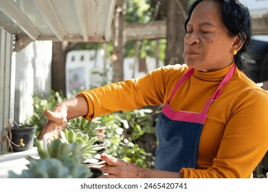 Elderly Mexican woman taking care of her plants and her garden - Powered by Shutterstock