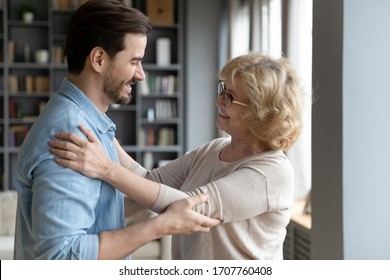 Elderly mother admires matured adult son looking at him smiles enjoy long awaited meeting after separation feels happy and proud, side view. Loving grown up child visited mom, familial ties concept - Shutterstock ID 1707760408