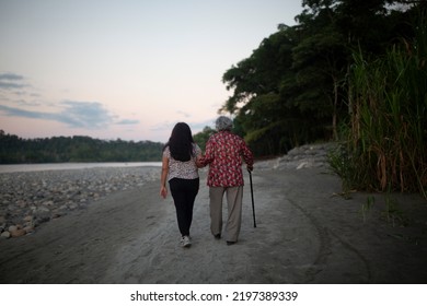 Elderly Mother And Daughter Walking In An Amazon River On Summer Vacation