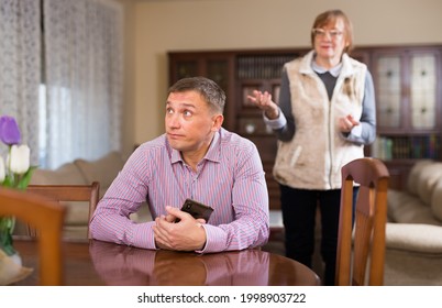Elderly mother threatens of her adult son at home. High quality photo