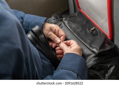 Elderly Old hands lying on top of the bag and holding the ticket.