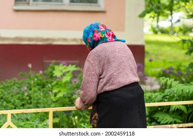An elderly old lady in Russia. Pensioner on the street. An old woman in a headscarf. Russian life of an ordinary grandmother. Walking the old lady in the street.