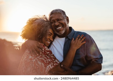 Elderly pair embraces at sunset, radiating joy and love by the seaside. A beautiful moment of togetherness and happiness. - Powered by Shutterstock