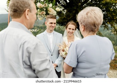 elderly parents with a young wedding couple after a wedding ceremony in the mountains - Powered by Shutterstock