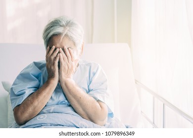 Elderly Patient Alone In Bed. Alone And Stress, Missing Her Grand Children. Hands On Face Pose. Very Senior, Old Chinese Woman.