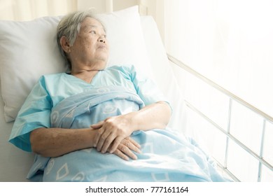 Elderly Patient Alone In Bed. Alone And Stress, Missing Her Grand Children. Looking At Window. Very Senior, Old Chinese Woman.