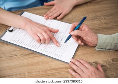 Elderly patient filling insurance at appointment with doctor in hospital or private clinic. Woman signing medical treatment contract agreement form for taking medic care service, consultation, therapy - Shutterstock ID 2337380315