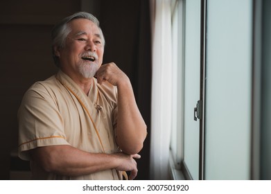 An Elderly Patient Look At City View Through Hospital's Window, Asian Old Man Smiling Look Very Comfort And Chill On His Face, Patient With Great Attitude, Happy Man Waiting For His Treatment. 