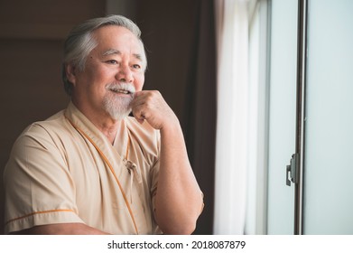 An Elderly Patient Look At City View Through Hospital's Window, Asian Old Man Smiling Look Very Comfort And Chill On His Face, Patient With Great Attitude, Happy Man Waiting For His Treatment. 