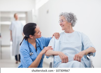 Elderly Patient Looking At A Nurse In Hospital Ward