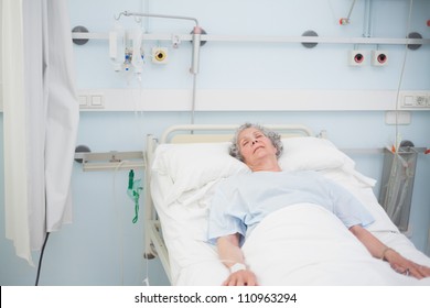 Elderly Patient Sleeping On A Medical Bed In Hospital Ward